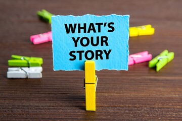 A blue note with what's your story held by a yellow clothes pin