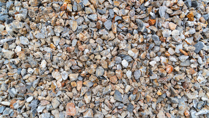 A full-frame, top-down view of a pile of small, multi-colored rocks and gravel