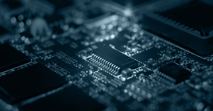 Close-up view of a detailed electronic circuit board with components illuminated in a dark environment