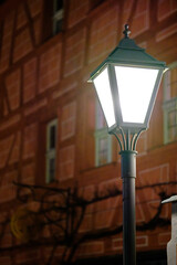 Laterne leuchtet mit Fachwerkhaus im Hintergrund