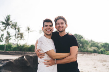 Warm beach hug between two happy men captures slow emotion and presence—embodied connection in...