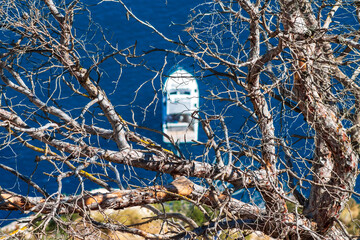 Seascape Serenity, A magnificent yacht glides on the calm blue sea, artfully framed by the...