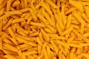 Penne Pasta Background. Uncooked Italian Macaroni Texture for Culinary Design
