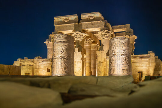 Majestic columns with carvings at Temple of Kom Ombo Egypt glow under night lights during a spring evening visit, highlighting ancient architecture.