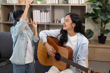 Musical Moments. Mother and son enjoying music together with guitar.