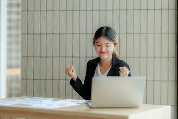 Confident Asian businesswoman celebrating her success with a bright smile.