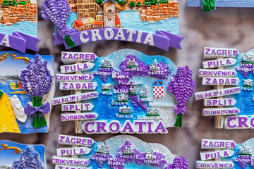 Colorful souvenir fridge magnets from Croatia, featuring maps, city names like Zagreb, Split, and...