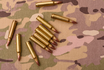 Machine gun cartridges on a camouflage background, military wallpaper. Camouflage background