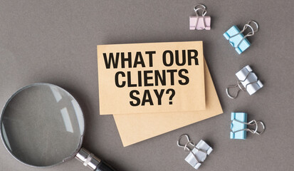 A magnifying glass is on top of a piece of paper that says What our Clients Say