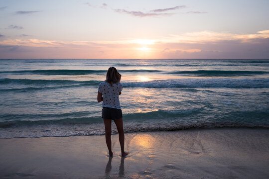 woman walking on the beach at sunset