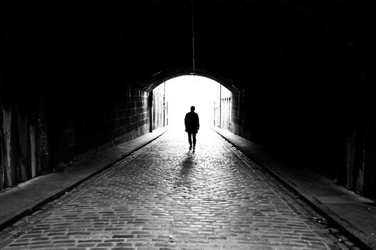 silhouette of a man walking in the tunnel