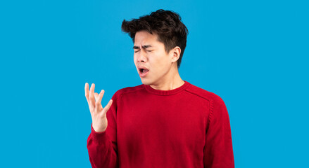 Wrong Way Of Coughing. Closeup portrait of asian guy in red sweater sneezing, spreading germs,...