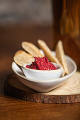 Beetroot dip with white bread on a wooden table