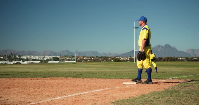 Running male pitcher onto mound at baseball field warming up, fielding throw and tossing ball back