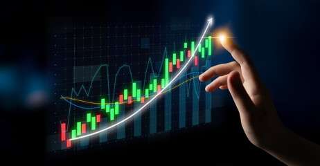 A hand interacts with a virtual stock market graph displaying an upward trend with vibrant colors,...