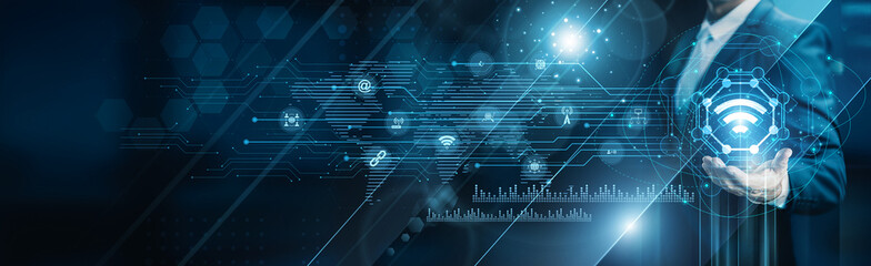 Businessman holding building of IoT networks, connected devices sensors automation data exchange...