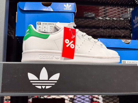 Adidas Stan Smith White Sneakers with Green Heel Tab and Red Sale Tag Displayed on Store Shelf, Dnipro, Ukraine - July 3, 2025