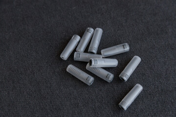 Collection of Gray Colored Plastic Tubes on a Black Surface: Examining Everyday Objects with Unique Shapes and Textures
