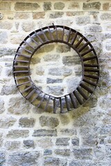 Rusty circular metal grate on a stone wall