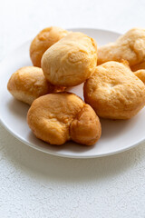 Golden Fried Dough Pieces on a White Plate: Classic American Treat Perfect for Any Occasion