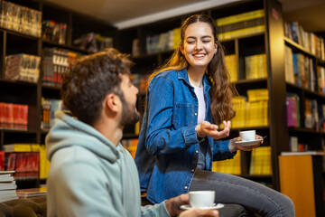 Students talking over coffee in library cafe