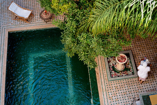 Oriental hospitality. Traveling by Morocco. Relaxing in festive moroccan traditional riad interior with swimming pool.