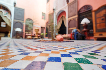Colorful tiled courtyard with a central fountain and arched doorways, featuring a mix of...