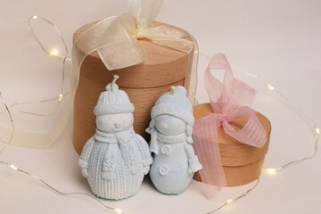 A winter composition featuring snowmen figurines, wooden gift boxes, and garlands—a charming...