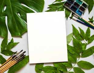 Blank Paper Surrounded by Greenery and Painting Supplies