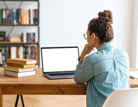 Woman Focused on Laptop Screen in Library Environment