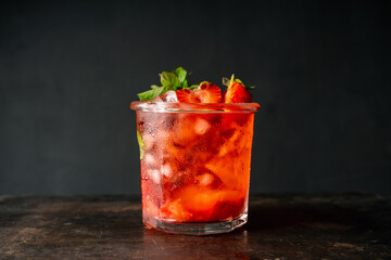 Fresh summer cocktail with strawberry and ice. Strawberry soda drink on the rustic background....