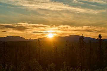 sunset over Nordic wilderness with endless boreal forest.