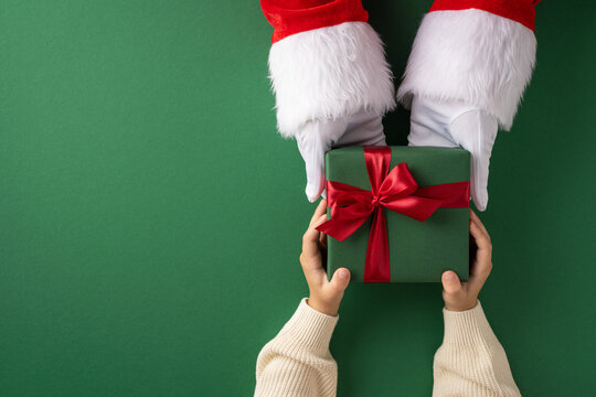 Santa Claus presents a festive green gift box to a child with a joyful holiday spirit - Powered by Adobe