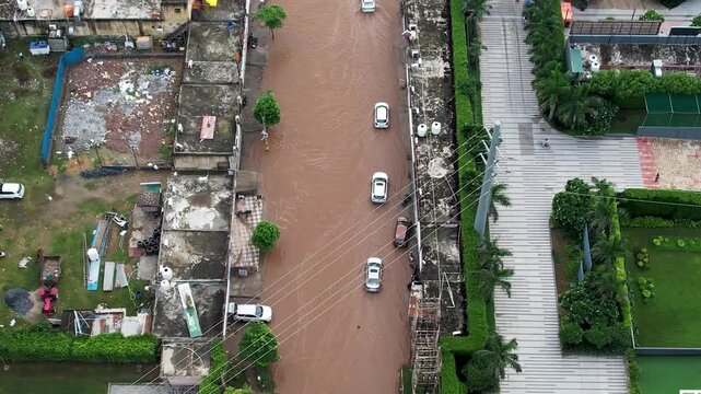 Aerial drone shot cars crossing flooded streets leading to damage and delays owing to poor road infrastructure and poor maintenance in Gurgaon, Delhi, Bangalore, Mumbai India during monsoons