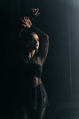 A mysterious woman stands in silhouette against a bright window, surrounded by dramatic smoke and...