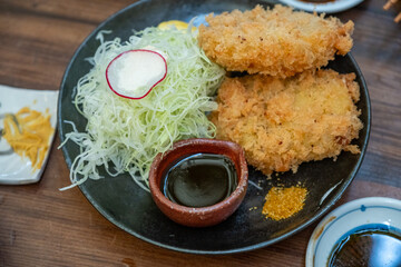 Breaded seafood cutlet with cabbage slaw and dipping sauce on plate