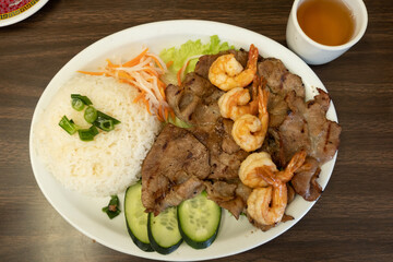 Grilled shrimp and pork rice plate with cucumber and pickled vegetables