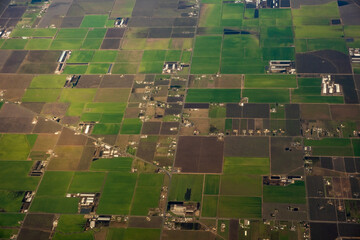Aerial farmland patchwork with fields in various shades of green and brown, February 6, 2023