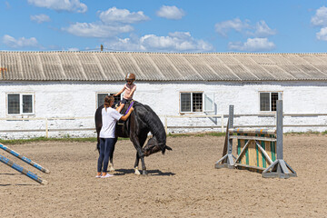 Child Horse Riding Lesson with Female Trainer on Outdoor Arena