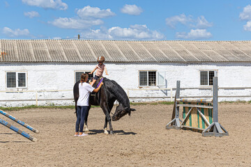 Child Horse Riding Lesson with Female Trainer on Outdoor Arena