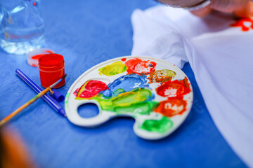 Colorful paint palette and brush on blue background