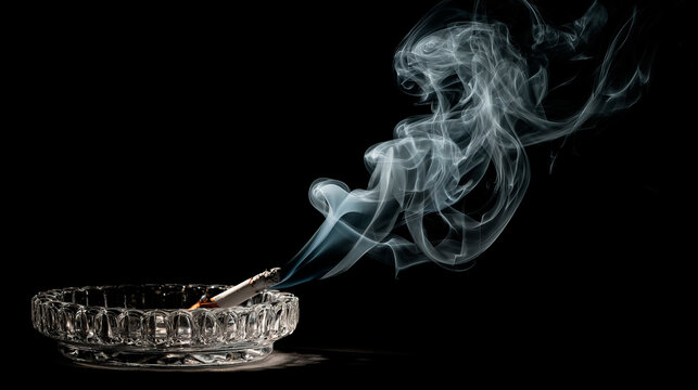 A smoldering cigarette left in a heavy, crystal glass ashtray. A delicate, elegant wisp of white smoke rises in a complex pattern. - Powered by Adobe