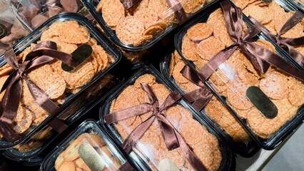 Transparent gift containers with homemade cookies tied with brown ribbons are the perfect visual...