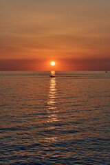 Sunset over Ocean with Silhouetted Boat