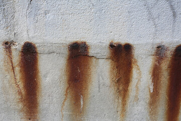 Morceaux de métal qui rouillent et dégoulinent sur un mur blanc