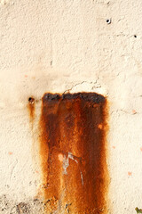 Morceaux de métal qui rouillent et dégoulinent sur un mur blanc