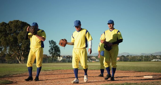 Four mature men in uniforms walking from outfield to dirt mound after final out, carrying gloves