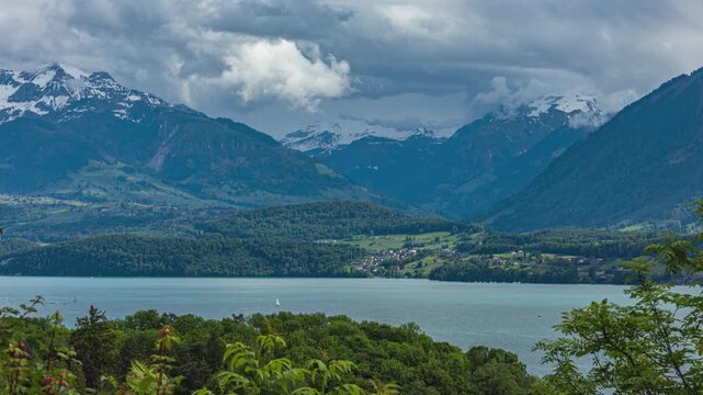 Time lapse of clouds passing mountains during summer. Grassy mountain valley. Thunersee, lake Thun, canton of Bern, Switzerland.
