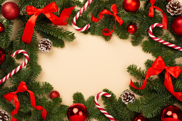 Christmas tree branches with festive decoration on color background, top view