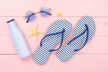 Striped blue flip flops with accessories on wooden background, top view